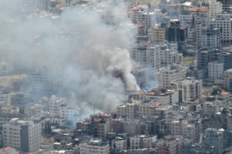Smoke billows from the war-torn Gaza Strip, seen from a US military transport aircraft 