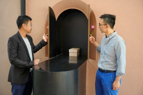 Paul Mui (L) and Benny Lee (R), founding directors of BREADstudio, which designed the Home of Forever Love, reenact a cremation ceremony