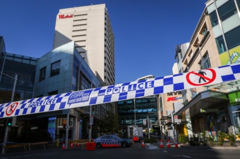 Police tape can be seen in front of a roadblock outside the Westfield Bondi Junction shopping mall in Sydney on April 14, 2024, the day after a 40-year-old knifeman with mental illness roamed the packed shopping centre killing six people