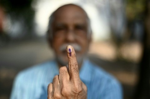 A man shows his inked finger after casting his vote at a polling station in southern India's Chennai