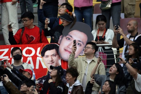 Fans hold banners with the face of Chinese driver Zhou Guanyu at the Shanghai International circuit