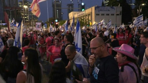Protesters in Tel Aviv wave flags and placards, and chant slogans calling for the resignation of Israeli Prime Minister Benjamin Netanyahu