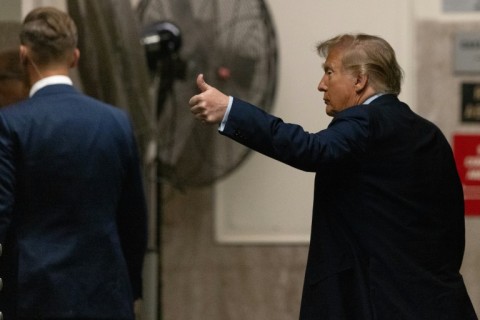 Former US president Donald Trump gestures to reporters during a break in proceedings at his hush money trial on April 26, 2024