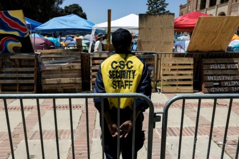 A security guard monitors the UCLA encampment
