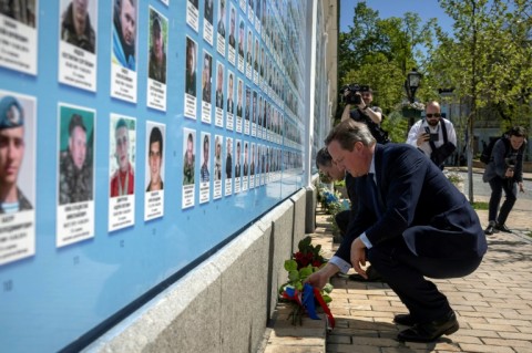 Cameron lays flowers at a memorial wall to servicemen killed defending Russia's attack during a visit Kyiv this month