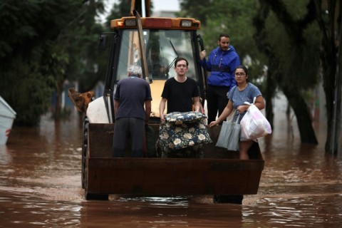 A construction vehicle carries evacuees from a flooded area of the Sao Geraldo neighborhood in Porto Alegre, on May 4, 2024