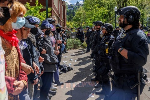 Pro-Palestinian students and activists face police officers after protesters were evicted from the library on campus earlier in the day at Portland State University in Portland, Oregon, on May 2, 2024