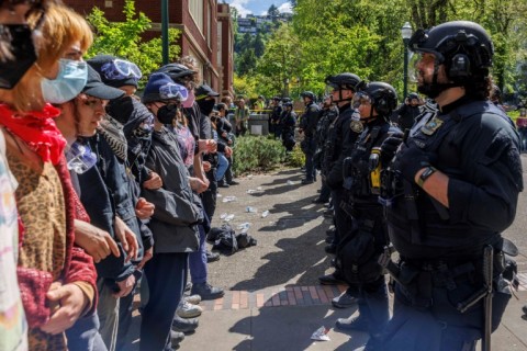Pro-Palestinian students and activists face police officers after protesters were evicted from the library on campus earlier in the day at Portland State University in Portland, Oregon, on May 2, 2024