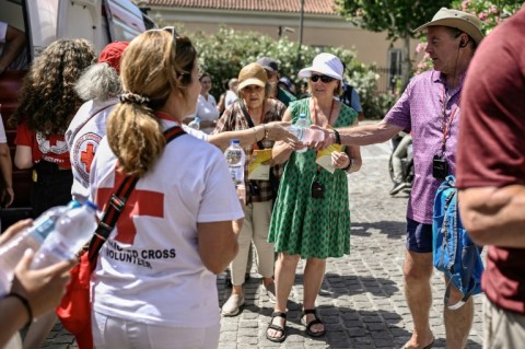 Volunteers of the Hellenic Red Cross hand out bottles of water at the Acropolis hill in Athens in July 2023 as Greece was hit by a heatwave
