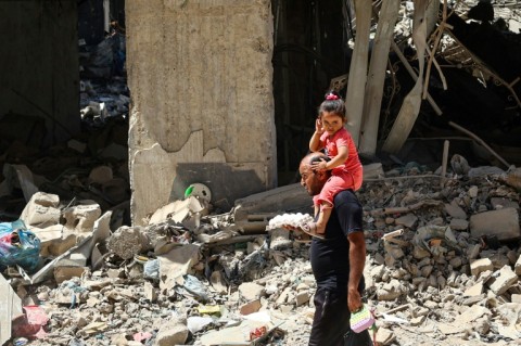 Boys watch smoke billowing during Israeli strikes east of Rafah