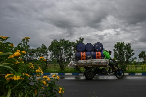 People move through a waterlogged street in India's city of  Kolkata
