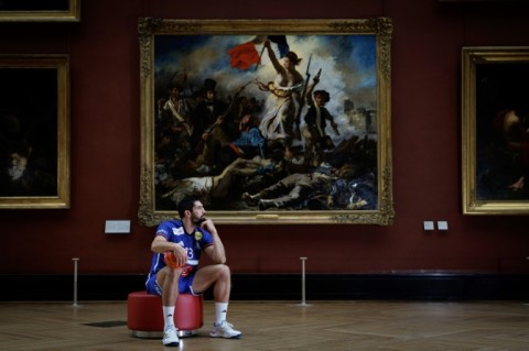 French handball player Nikola Karabatic poses in the Louvre  in front of the iconic painting by Eugene Delacroix 'Liberty Leading the People' commemorating the July Revolution of 1830 