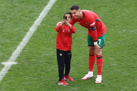 A young pitch invader takes a selfie with Cristiano Ronaldo during Saturday's Euro 2024 match between Portugal and Turkey in Dortmund