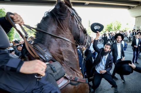 Israeli mounted police in the city of Bnei Brak disperse ultra-Orthodox Jewish men during a protest against a ruling by a top Israeli court that they must be drafted into military service