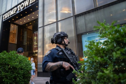 Law enforcement stand guard outside of Trump Tower in New York City after the rally shooting