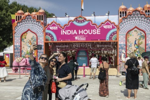 Visitors take selfies at the entrance of the India House at Parc des Nations