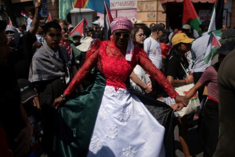 A woman wears a dress in the colours of the Palestinian flag as she takes part in a pro-Palestinian march in Cape Town