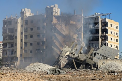 A man searches through the rubble of Maghazi refugee camp in Gaza after an Israeli strike 