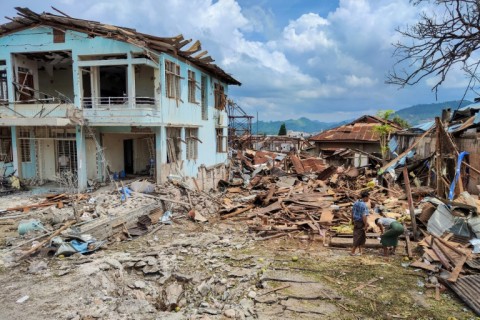 People clean up debris of in the aftermath of bombardments carried out by Myanmar's military in Lashio