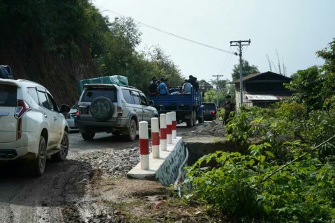 Vehicles are stopped at a security checkpoint on the road to Muse