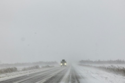 A Ukrainian armoured military vehicle drives along a road during snowfall in the eastern Donetsk region