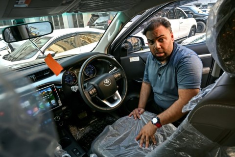 Car dealer Fahad Nazir shows AFP the inside of a Toyota Hilux pick-up truck, locally known as a 'Dala', at his lot in Karachi