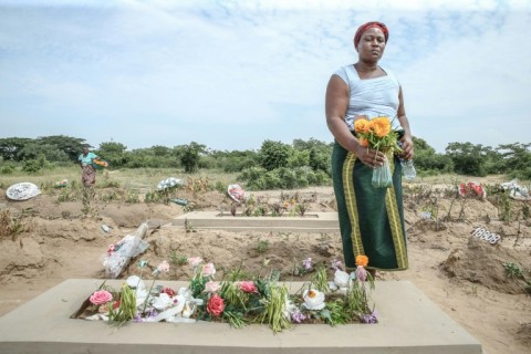 Ana Madivage brings flowers to the grave of her son killed in post-election violence in Mozambique