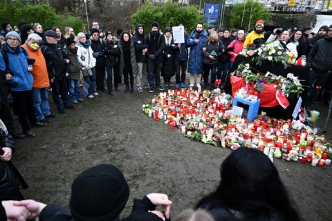 People gather at a makeshift memorial of candles and flowers for the victims of a knife attack, on January 24, 2025 in Aschaffenburg, western Germany