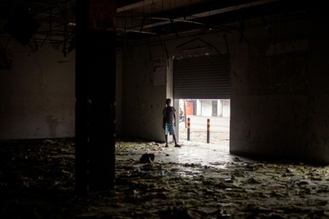 A boy inspects a looted supermarket as residents gradually return to the streets of Goma