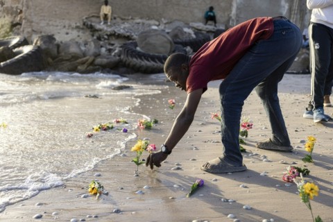 Families of those lost at sea placed flowers on the beach in memory of their loved ones