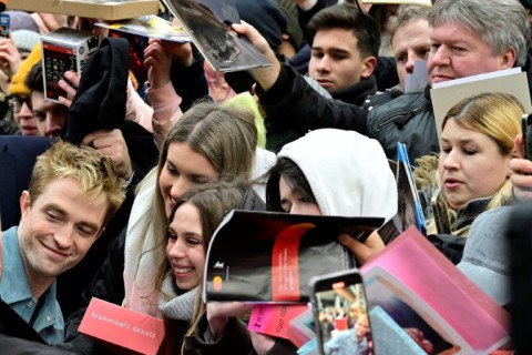 English actor Robert Pattinson poses for a selfie after a press conference for the film "Mickey 17" at the 75th Berlinale