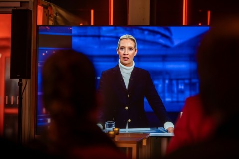 People watch a TV screen showing the co-leader and main candidate of the far-right Alternative for Germany (AfD) party Alice Weidel 