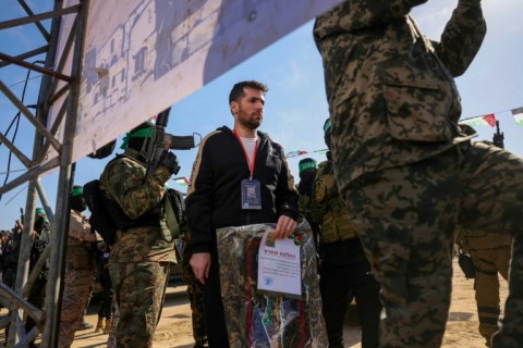 Hamas militants escort Israeli-American hotsage Sagui Dekel-Chen onto a stage in Khan Yunis before handing him over to the Red Cross
