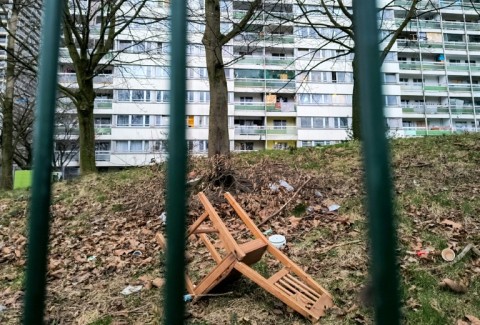 A broken chair lies amid some litter on a green space at the Hochheide Estate in Duisburg, western Germany