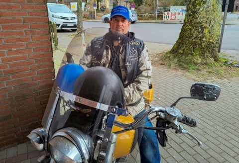 63-year-old Alternative for Germany (AfD) member Ludger Schulppen sits on his motorcycle with a 'Make Duisburg Great Again' cap