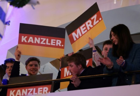 Supporters hold up signs reading 'Chancellor' and 'Merz' during the final campaign event of the Christian Democratic Union party in Munich