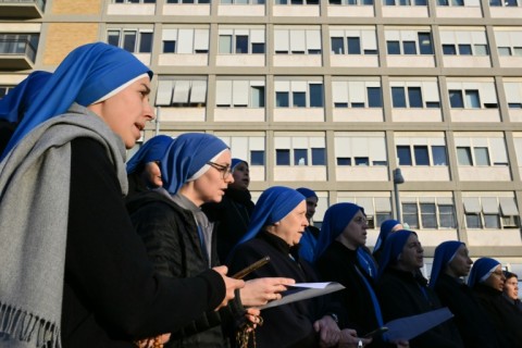 Nuns sing at the statue of John Paul II outside the Gemelli hospital where Pope Francis is hospitalized in Rome 