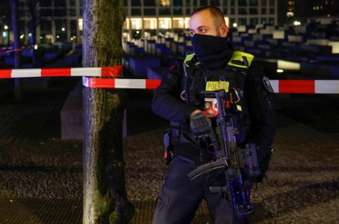 An armed police officer at the cordoned off scene of the stabbing attack
