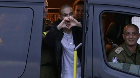 Released Israeli hostage waves to crowd after arriving at hospital