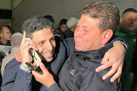 A Palestinian prisoner speaks to relatives on the phone at the European Hospital in Khan Yunis, southern Gaza, following his release by Israeli authorities