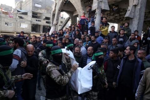 Palestinians and Hamas fighters attend a funeral procession for 40 militants and civilians killed during the war with Israel