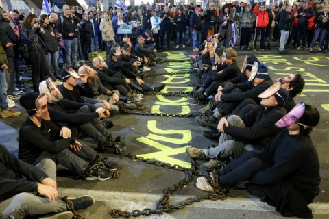 Israeli demonstrators sit together in chains during a protest in Tel Aviv calling for action to release the remaining hostages held captive in Gaza