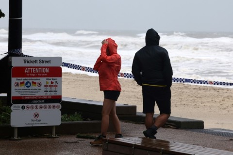 People watch waves at Surfers Beach on Australia's Gold Coast as former Cyclone Alfred nears