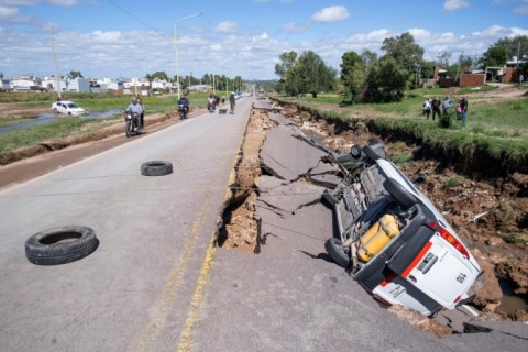 Overturned vehicles on a storm-damaged road in Bahia Blanca, Argentina