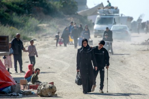 Israeli army soldiers walk past tanks at a position near Israel's southern border with the Gaza Strip