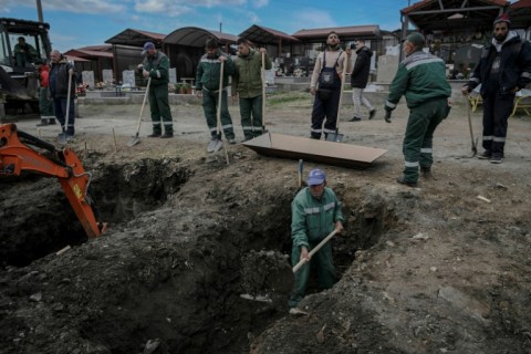 Cemetery workers dug graves on the outskirts of town