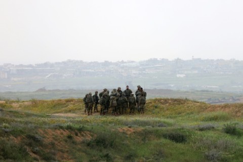 Israeli soldiers stand in a position along Israel's southern border with the Gaza Strip on March 20