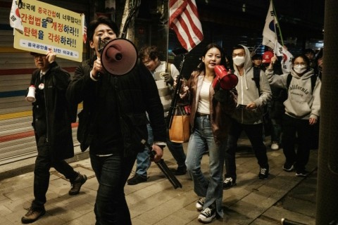 Supporters of impeached South Korean President Yoon Suk Yeol shout at protesters against him as they march past each other on a street