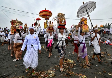 Hindu devotees take offerings to a beach near Denpasar