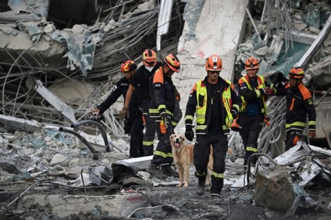 K-9 units search for missing persons at the site of the under-construction building collapse in Bangkok